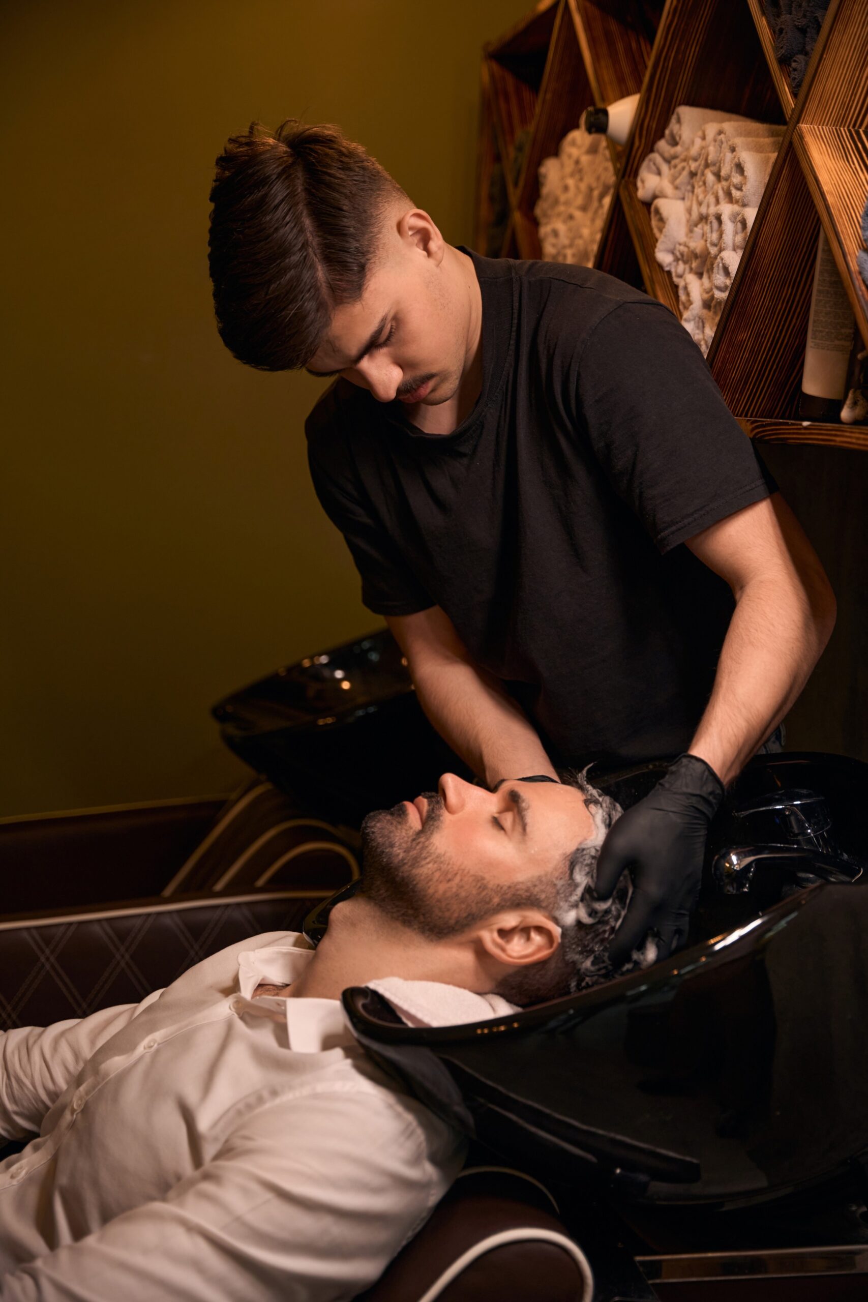 hairdresser-man-washing-client-head-with-shampoo-CMU56AW-scaled.jpg